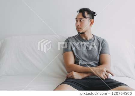 Inattentive vacant lonely man sitting at the sofa look at empty space. 120764500