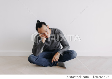 Lonely Freelance creative man sitting alone in empty white room. 120764526