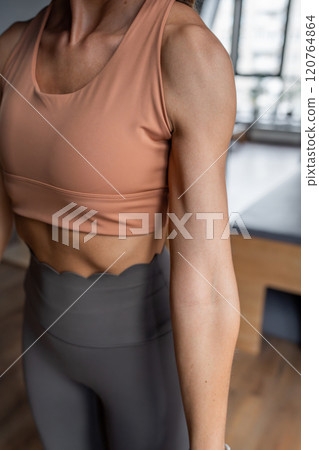 Pilates fitness trainer beautiful hand and shoulders relief. Pilates studio. Young sporty attractive woman wearing sportswear in yoga studio. Fit, healthy and strong authentical body. Fitness concept Pilates fitness trainer beautiful hand and shoulders relief. Pilates studio. Young sporty attractive woman wearing sportswear in yoga studio. Fit, healthy and strong authentical body. Fitness concept 120764864
