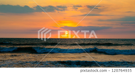 Bright golden sunrise over the tropical sea. Wide photo. 120764935