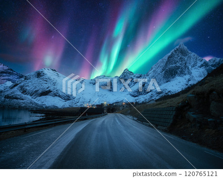Northern lights over road, snowy mountains, village at night Northern lights over road, snowy mountains, village at night 120765121