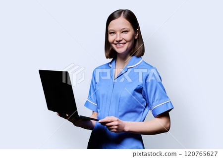 Female nurse with laptop, looking at camera on white studio background 120765627