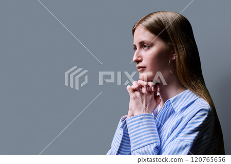 Profile view, young serious female looking forward on gray studio background Profile view, young serious female looking forward on gray studio background 120765656