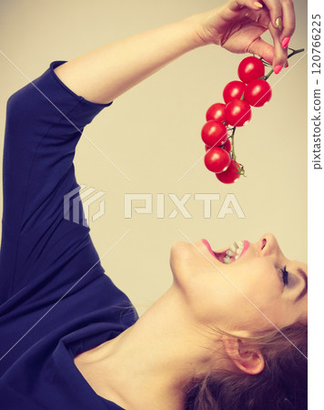 Woman holding eating fresh cherry tomatoes 120766225