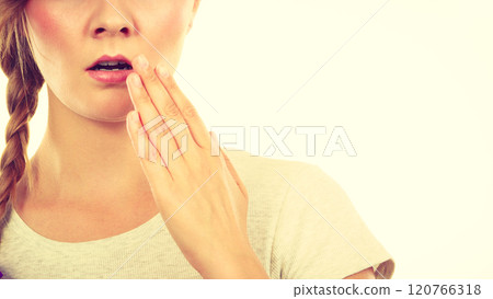 Upset teenage woman with hand close to lips 120766318