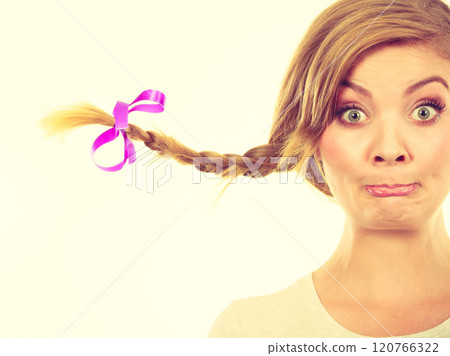 Teenage girl in braid hair making funny face Teenage girl in braid hair making funny face 120766322