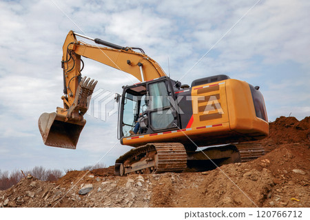 Excavator at Construction Site on Dirt Hill 120766712