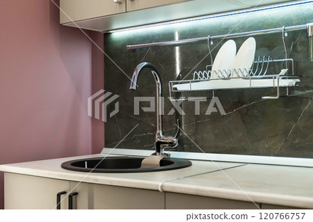 Modern kitchen sink with hanging dish rack and plates drying Modern kitchen sink with hanging dish rack and plates drying 120766757