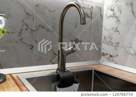 Modern kitchen faucet with sponge holder and marble tile backsplash Modern kitchen faucet with sponge holder and marble tile backsplash 120766759
