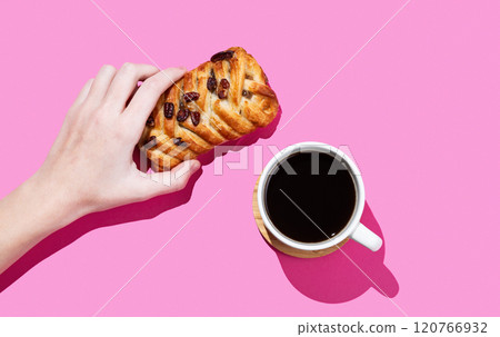 Hand holding a maple pecan bun on a pink background with cup of espresso coffee and shadow. Hand holding a maple pecan bun on a pink background with cup of espresso coffee and shadow. 120766932