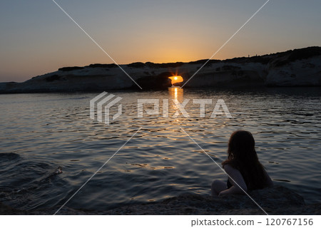 Woman Watching Sunset through Rock Arch 120767156