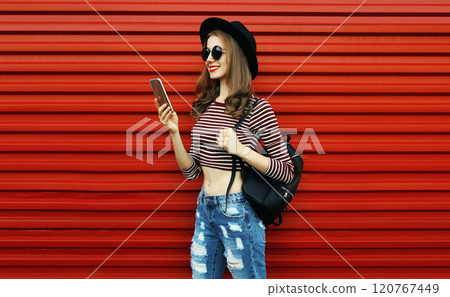 Portrait of stylish young woman with smartphone on a red background Portrait of stylish young woman with smartphone on a red background 120767449