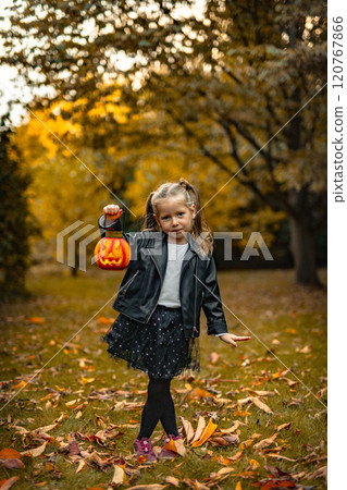 little girl smiles in a Halloween in Park in autumn 120767866