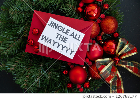 Christmas handmade wreath made of festive decorations with red envelope and paper note with JINGLE ALL THE WAY text. Winter holiday celebration greeting card Christmas handmade wreath made of festive decorations with red envelope and paper note with JINGLE ALL THE WAY text. Winter holiday celebration greeting card 120768177