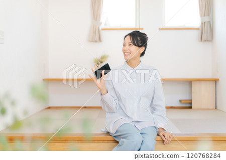 一位女士放鬆地坐在凸起的榻榻米墊上 120768284