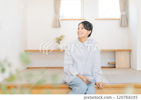 一位女士放鬆地坐在凸起的榻榻米墊上 120768285