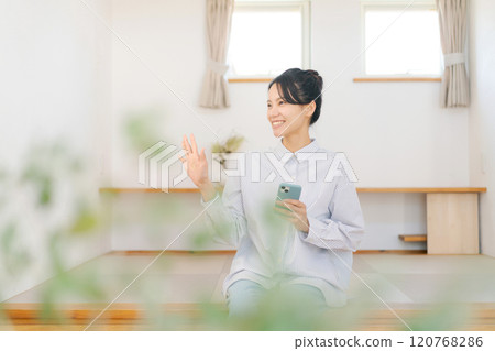 一位女士放鬆地坐在凸起的榻榻米墊上 120768286