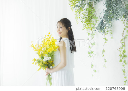 Young woman holding a bouquet of mimosa 120768906