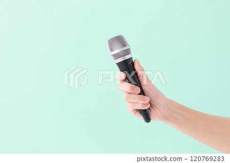 A man's hand holding a microphone (stock photo) 120769283