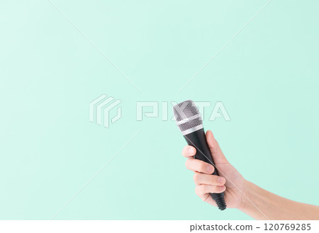 A man's hand holding a microphone (stock photo) 120769285