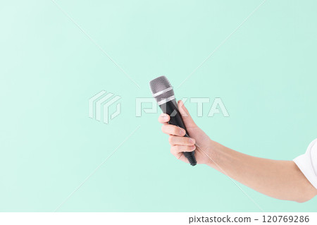 A man's hand holding a microphone (stock photo) 120769286