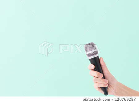 A man's hand holding a microphone (stock photo) A man's hand holding a microphone (stock photo) 120769287