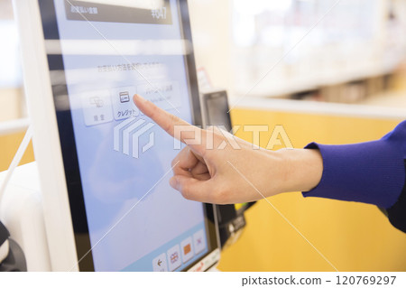 Woman's hand paying at a self-checkout Woman's hand paying at a self-checkout 120769297