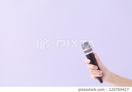 A man's hand holding a microphone (stock photo) 120769427