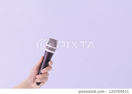 A man's hand holding a microphone (stock photo) 120769431