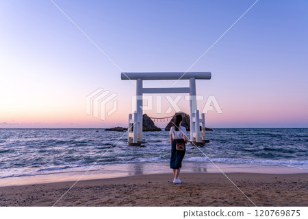 傍晚，福岡縣糸島市，一名婦女在櫻井二見浦的夫妻岩和白色鳥居前擺姿勢。 120769875