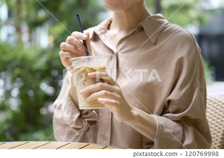 Woman drinking cafe au lait on the terrace of a cafe, no face Woman drinking cafe au lait on the terrace of a cafe, no face 120769998