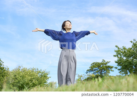 A woman taking a deep breath outside A woman taking a deep breath outside 120770004
