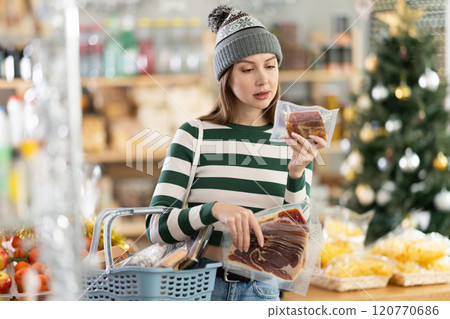 Young woman is looking and choose hamon in store. Young woman is looking and choose hamon in store. 120770686