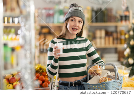 Visiting store on New Years Eve, girl is looking at something on shelf of showcase. Visiting store on New Years Eve, girl is looking at something on shelf of showcase. 120770687