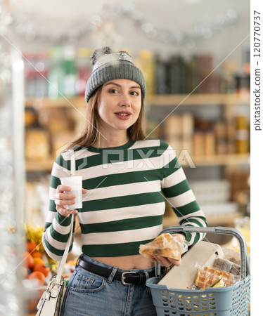 Visiting store on New Years Eve, girl is looking at something on shelf of showcase. 120770737