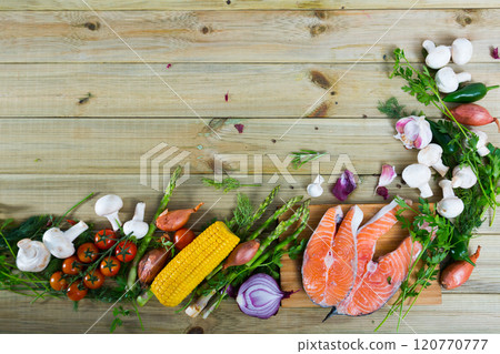 Vegetables, steaks of salmon, mushrooms on wooden background 120770777