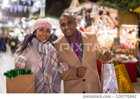Positive couple buying decoration at Christmas Fair outdoor Positive couple buying decoration at Christmas Fair outdoor 120770842