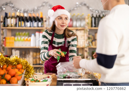 Female seller weighs candies for guy buyer 120770862