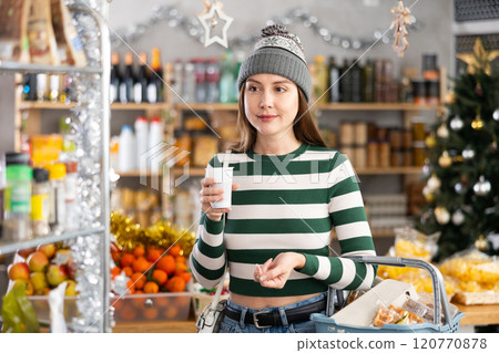Visiting store on New Years Eve, girl is looking at something on shelf of showcase. Visiting store on New Years Eve, girl is looking at something on shelf of showcase. 120770878