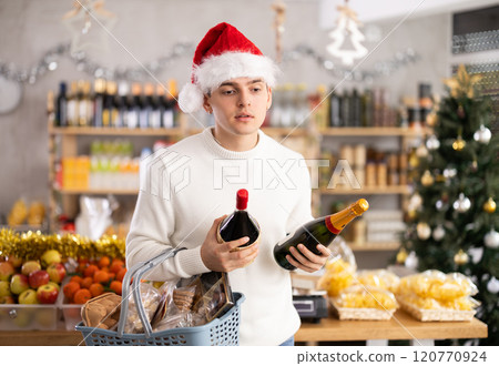 Young guy choosing wine in grocery store 120770924
