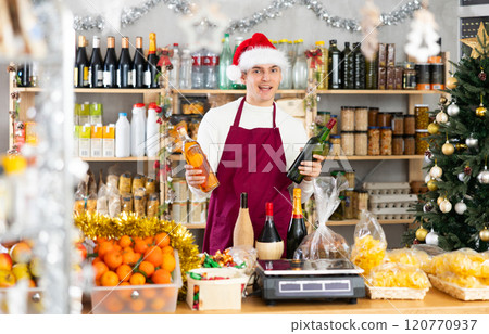 Young guy seller offers alcohol in grocery store Young guy seller offers alcohol in grocery store 120770937