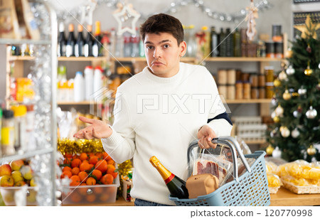 Visiting store on New Years Eve, guy is looking at something on shelf of showcase. 120770998