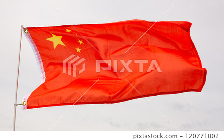 Flag of China waving on flagpole in wind against cloudy sky 120771002