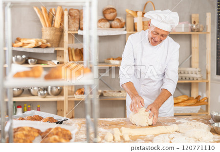Senior man works in bakery as baker, kneads dough, works with flour. Senior man works in bakery as baker, kneads dough, works with flour. 120771110