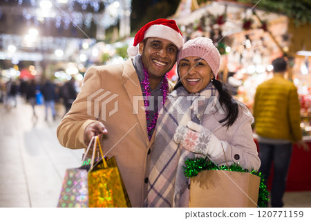Positive couple buying decoration at Christmas Fair outdoor 120771159