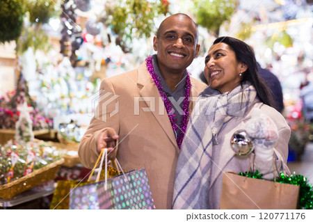 Portrait of happy elegant couple with gift bags at new year fair 120771176