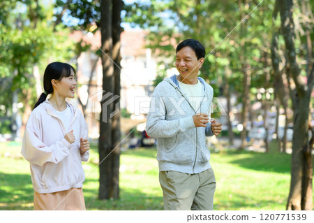 Active senior man and his daughter wearing athletic clothing enjoy their morning run in the fresh air Active senior man and his daughter wearing athletic clothing enjoy their morning run in the fresh air 120771539