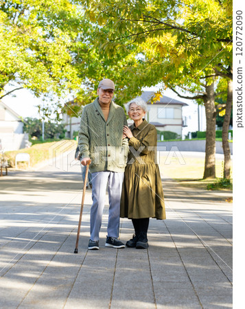 Senior couple: man with a cane and woman assisting him Senior couple: man with a cane and woman assisting him 120772090