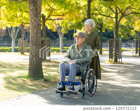 Senior couple: man in wheelchair and woman assisting him Senior couple: man in wheelchair and woman assisting him 120772115