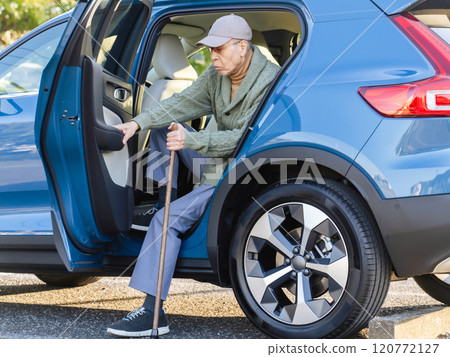 Senior man with a cane getting out of a car Senior man with a cane getting out of a car 120772127